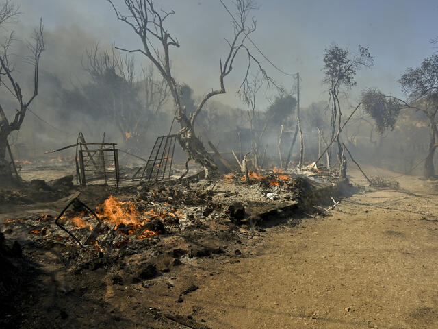 Fire burns through the remains of the Moria refugee reception center on Lesbos, Greece