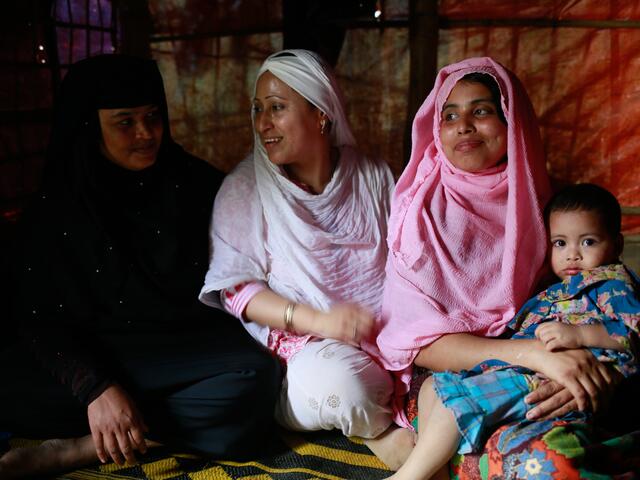 Rohingya activist and lawyer Razia Sultana sits with another Rohingya woman and her family in a refugee camp in Cox's Bazar, Bangladesh.