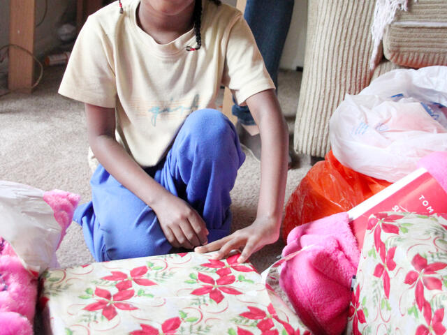 A refugee child opens a present