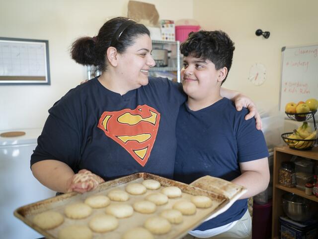 10-year-old Yousif holds a plate of freshly baked shakar lama (caradmom) cookies with his mom, Taghreed