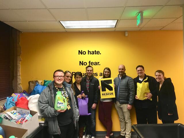 Goldman Sachs' employees standing in front of the International Rescue Committee in Salt Lake City sign.