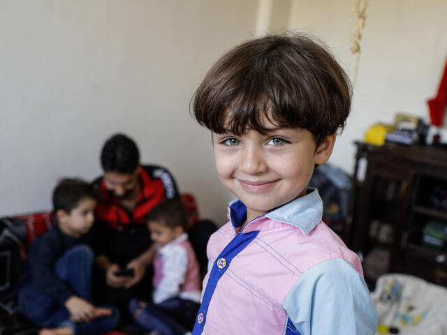 A smiling five-year-old Murad at home with his family in northwestern Syria.