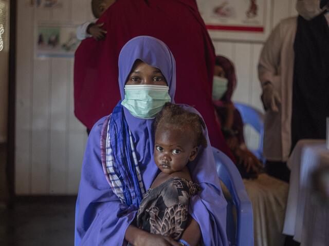 A woman holds her child as she receives treatment for malnutrition in the IRC clinic in Mogadishu. 