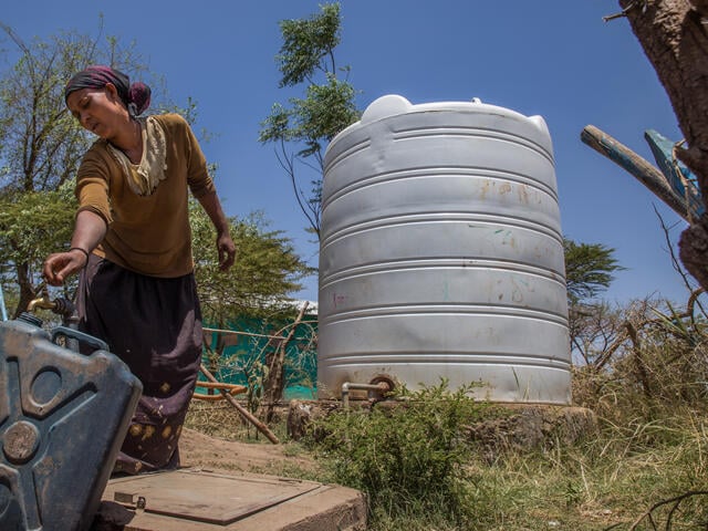 A woman fills a jerry can from a tap, part of a water system the IRC installed in Ethiopia.