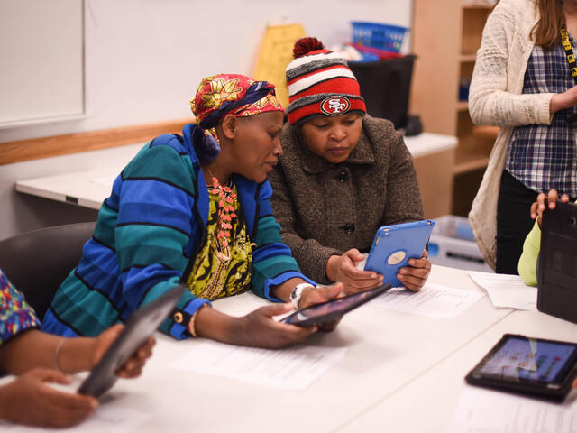 Two participants in a tablet workshop by the IRC in Salt Lake City's digital inclusion program look at their tablets