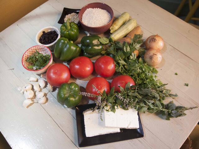 Tomater, paprika, lök, vitlök och andra ingredienser på ett bord. 
