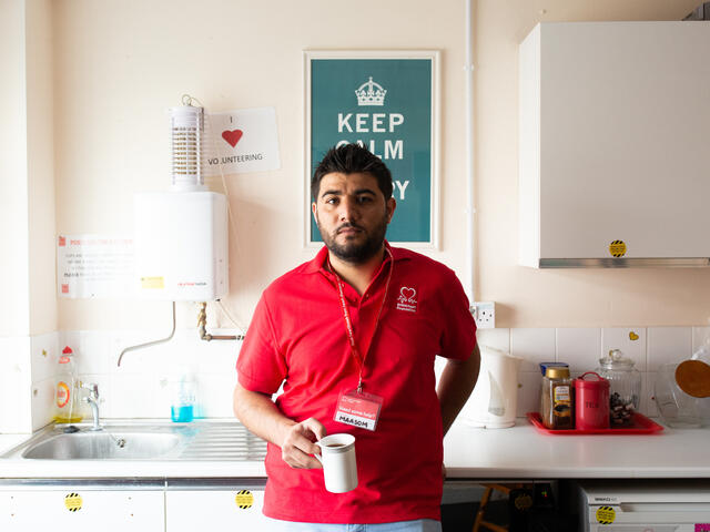 Maasom at a British Heart Foundation office, holding a coffee cup.