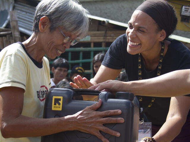 IRC aid worker Aisha Bain distributing emergency supplies to people affected by Typhoon Haiyan.