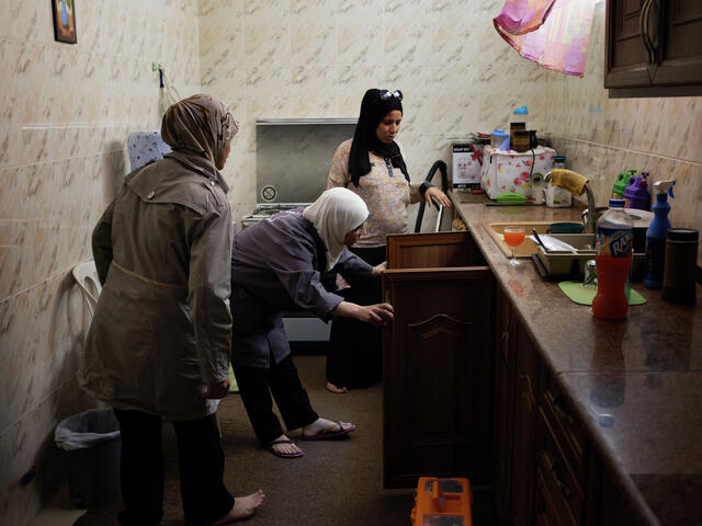 Two Syrian women plumbers visit a customer's home in Jordan