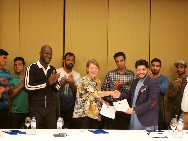 Regional director Sanna Johnson signs MOU with Peshawar Zalmi owner Javed Alfridi, alongside team captain Darren Sammy