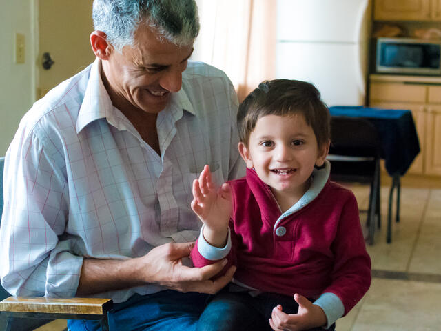 Two-year-old Khaled waves hello with his father