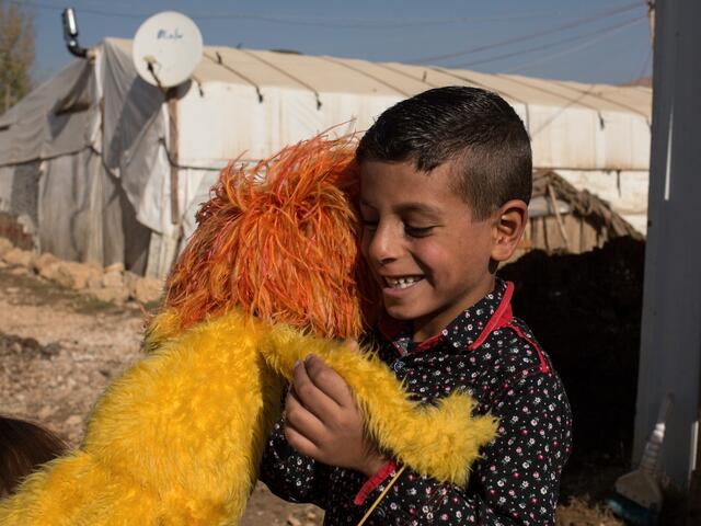 Syrian boy hugs Sesame Street Muppet