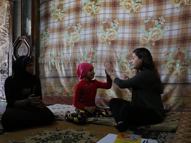 IRC aid worker with Syrian family