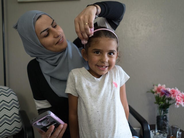 Bothina Matar adjusts her five-year-old daughter Jori's headband as she get sready for school.