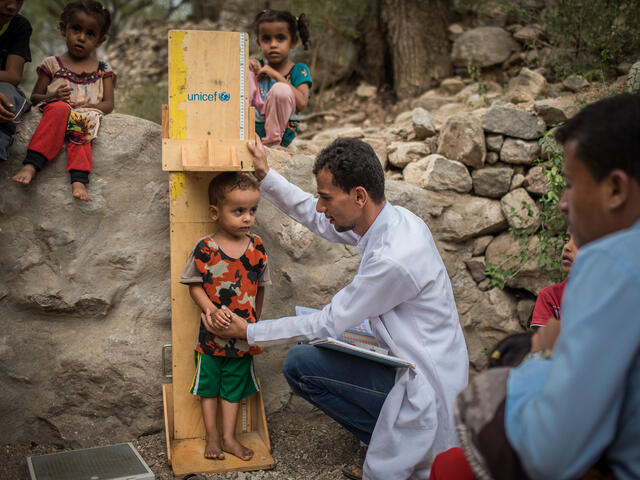 An IRC health worker measures a young boy as he screens him for malnutrition at an IRC mobile health clinic in Mosuk Village, Yemen
