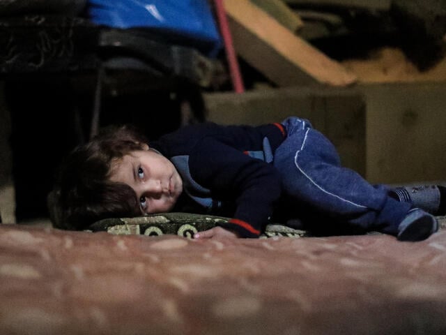 Syrian boy in underground bunker in Eastern Ghouta lying down