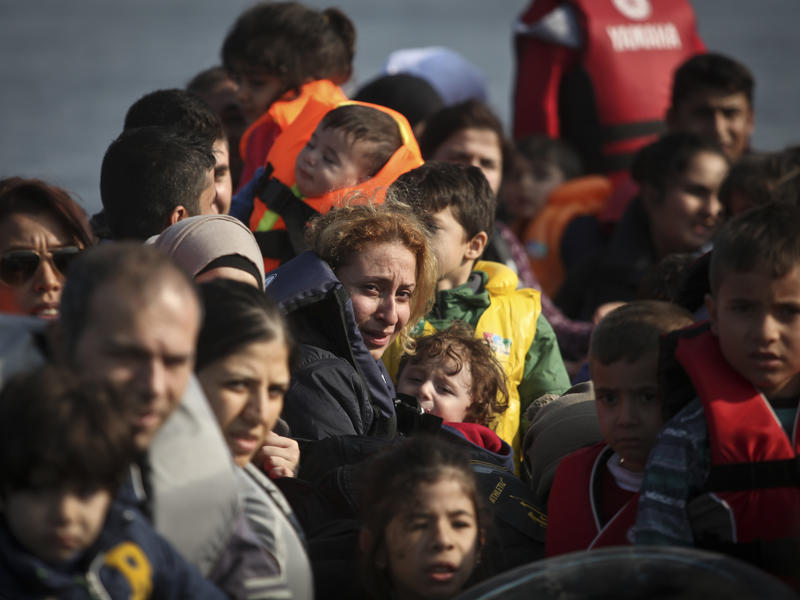 Syrian refugees, including women and children, approach the shores of Lesbos, Greece in an overcrowded rubber raft.