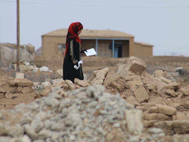After picking up a prescription at an IRC mobile clinic, a woman picks her way through rubble in a village in northeastern Syria that has been heavily damaged during the war. A woman picks her way through rubble in a village in rural, northeastern Syria that has been heavily damaged during the war.