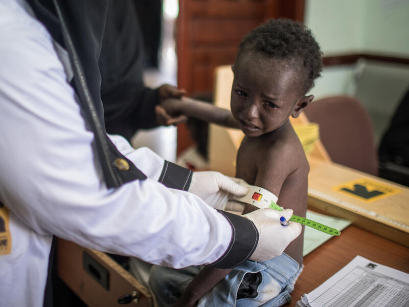 A boy is treated for malnutrition at an IRC-supported health clinic in Sana'a, Yemen. A health worker at an IRC-supported clinic in Sana'a, Yemen, measures a young boy's arm to confirm he is suffering from malnutrition.