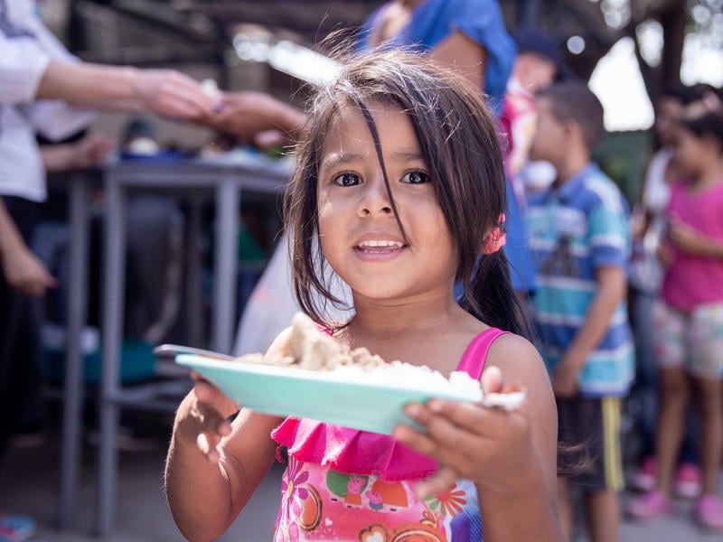 A Venezuelan girl holds a plate of food in Cúcuta, Colombia.