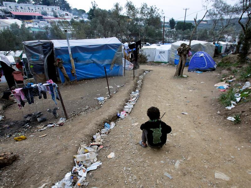 International Rescue Committee is providing support to refugees and asylum seekers in Moria reception center in Lesbos, Greece A child sis on the ground near tents in the Moria refugee camp on Lesbos, Greece