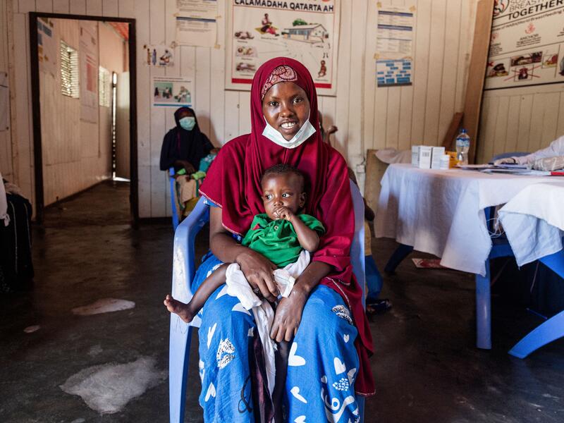 Farhiyo Abukar with her son Farhiyo Abukar sits in a chair in the IRC clinic with her son on her lap.