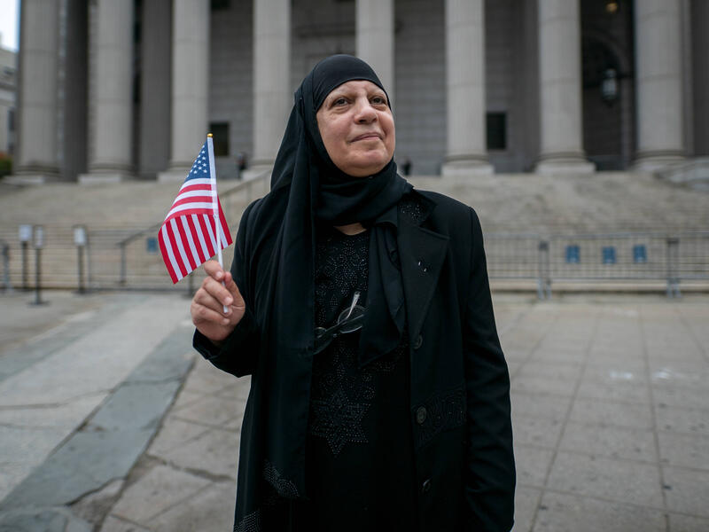 Maha al-Obaidi after obtaining her U.S. citizenship Maha al-Obaidi stands in front of the federal court house while holding a flag