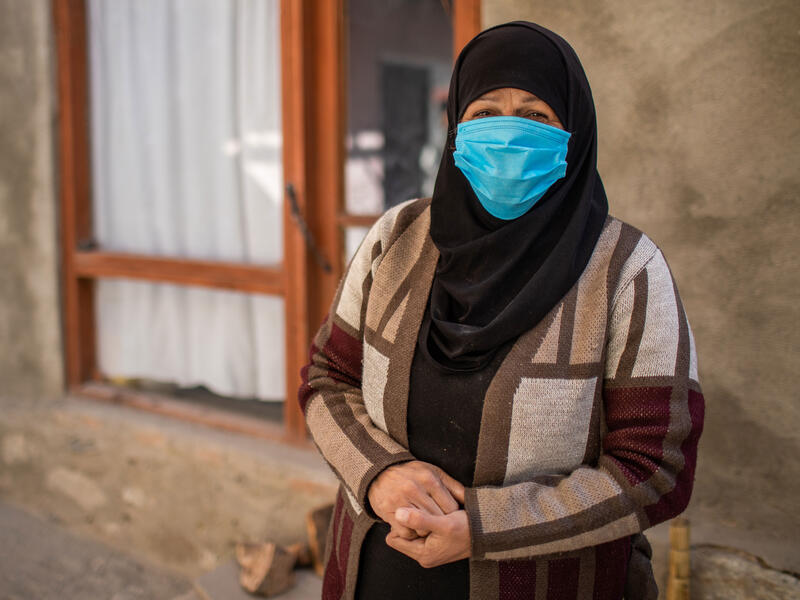 Zulaykha, a former human rights worker who had to flee her home in Afghanistan Wearing a mask, Zulaykha stands in front of a building and looks at the camera