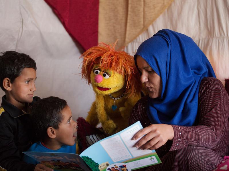 Syrian mother reads with her sons and a Sesame Street Muppet Tonton Syrian mother reads with her sons and a Sesame Street Muppet Tonton