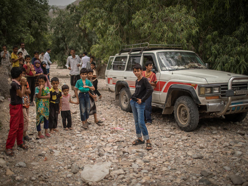 Children stand in front of an IRC mobile health team vehicle in a mountainous village in Yemen