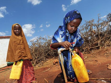 Two girls fetch water at an IRC-installed tap in Galkayo, Somalia. Photo: Peter Biro Two girls fill water jugs at an IRC-installed tap in Galkayo, Somalia