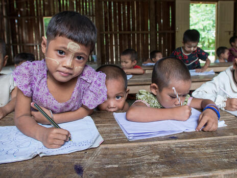 Refugee children in a classroom at a refugee camp in northern Thailand Refugee children hold pencils in a classroom at a refugee camp in northern Thailand