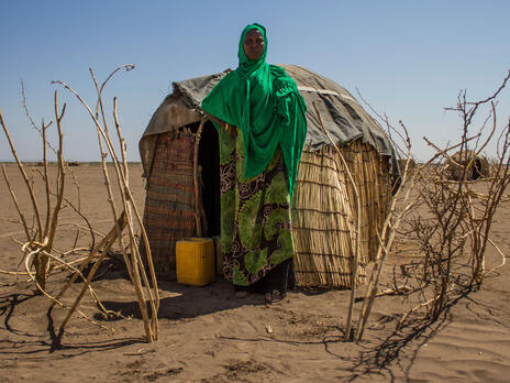 Sada Mohammed, 30, stands in front of her temporary shelter near a remote village in the Somali region of Ethiopia, which is experiencing the country's worst drought in 50 years. Woman stands in front of temporary shelter in drought-afflicted region.