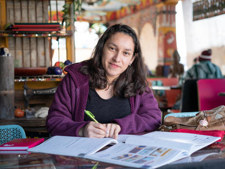Valentina, a young woman from El Salvador who was resettled by the IRC, poses with her schoolwork