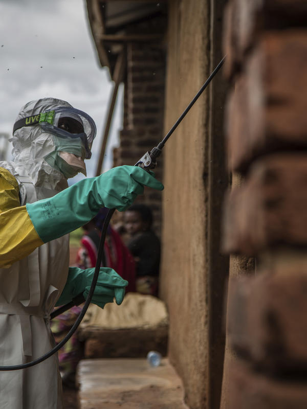 A health worker disinfects Case Du Salut health facility A health worker sprays disinfectant on Case Du Salut health facility
