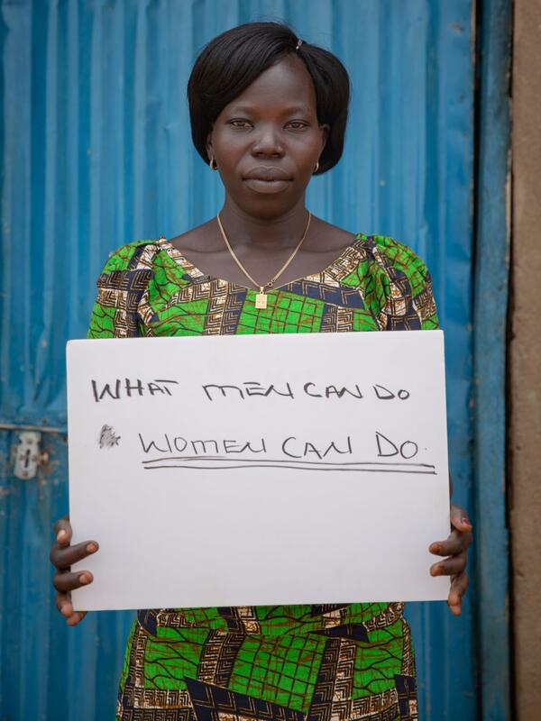 Foni holding her sign Foni holds a sign that says "What men can do, women can do."