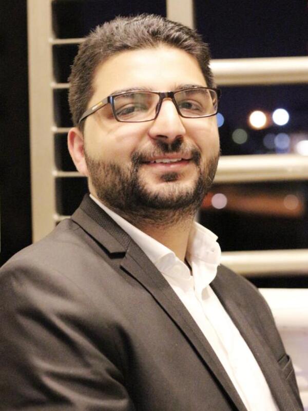 Dr. Abedalhaleem Albalasmeh, a doctor who works for the IRC in Jordan Dr. Abedalhaleem Albalasmeh, wearing a suit, smiles for the camera.