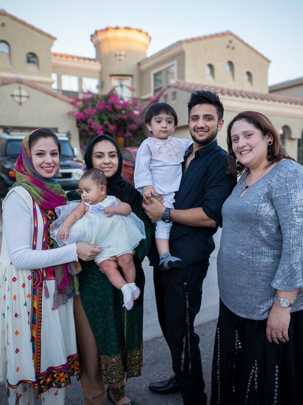 Resettled family stands in front of their home in the United States