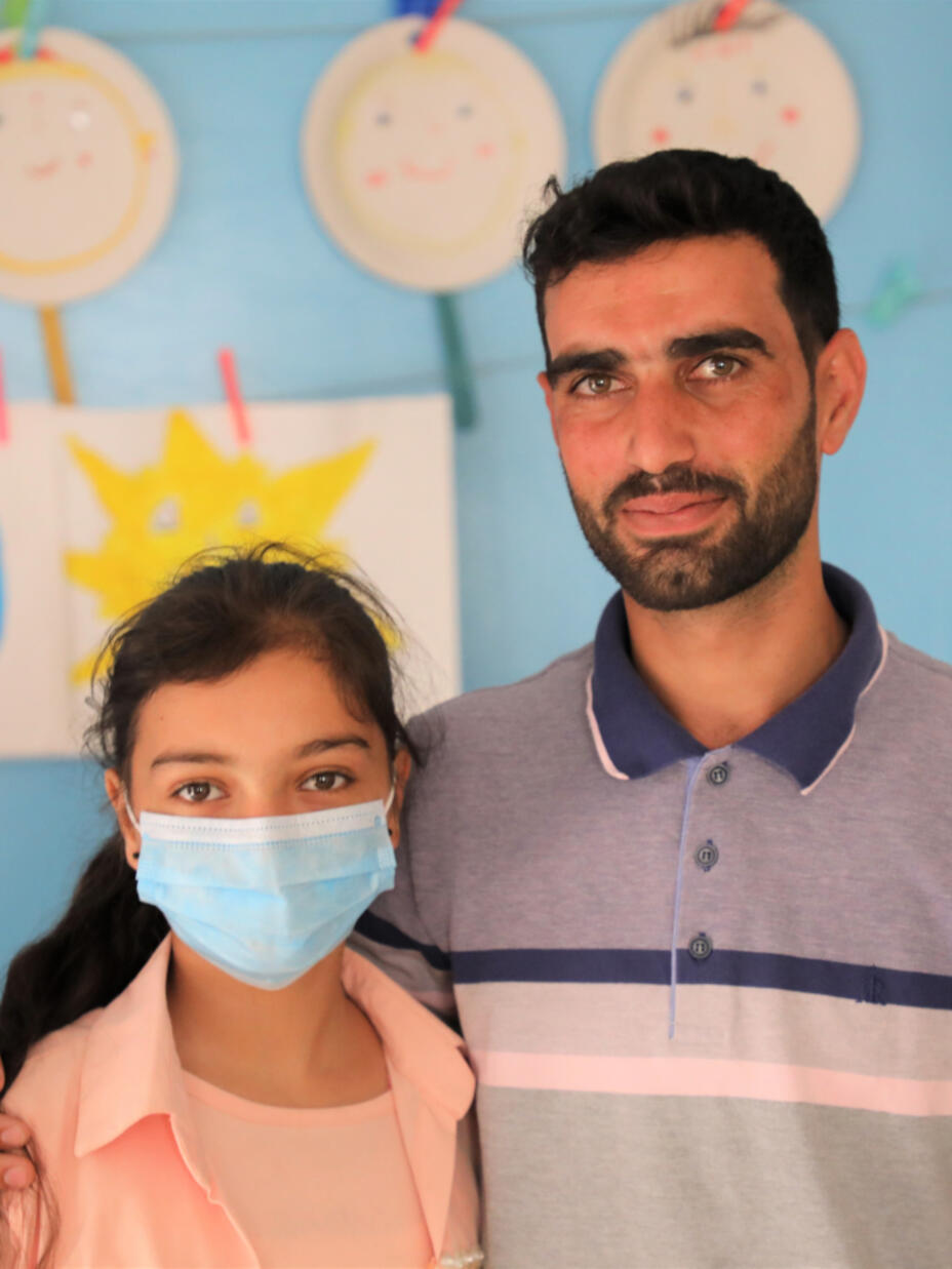 Joumana standing with her uncle in the IRC Child Protection Centre