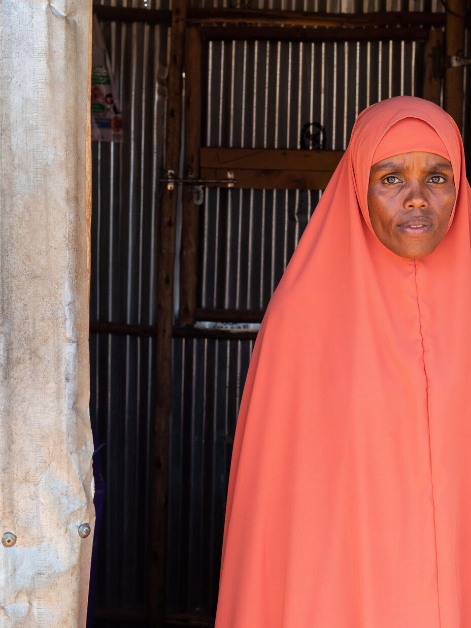 Portrait of 22 year old Misra, an IDP in Ethiopia's Qoloji camp, standing in front of a makeshift classroom