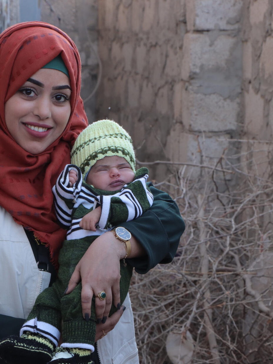 Portrait of Dr. Bushra holding a baby