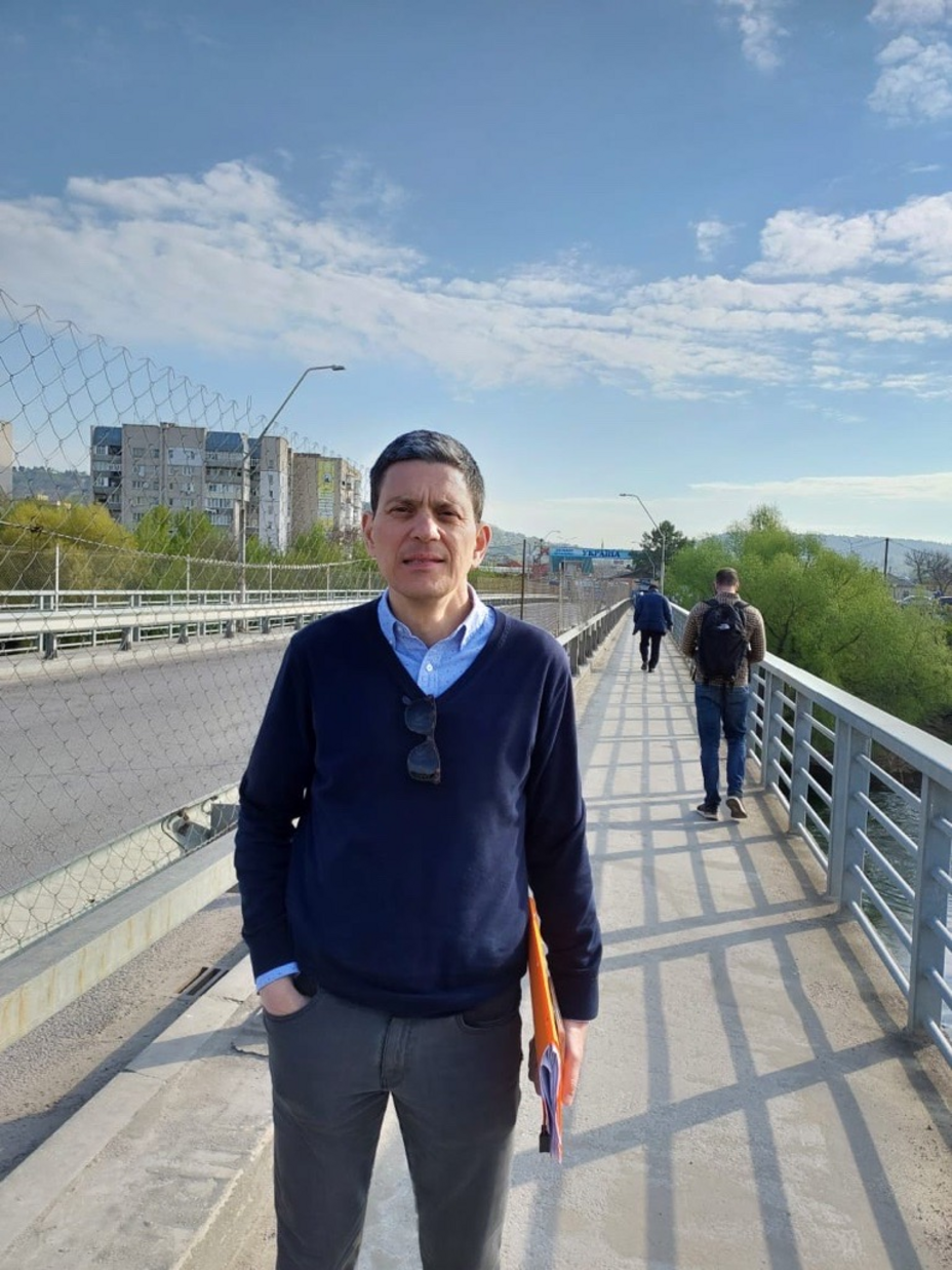David Miliband steht auf einer Brücke, die zur Grenze in die Ukraine führt