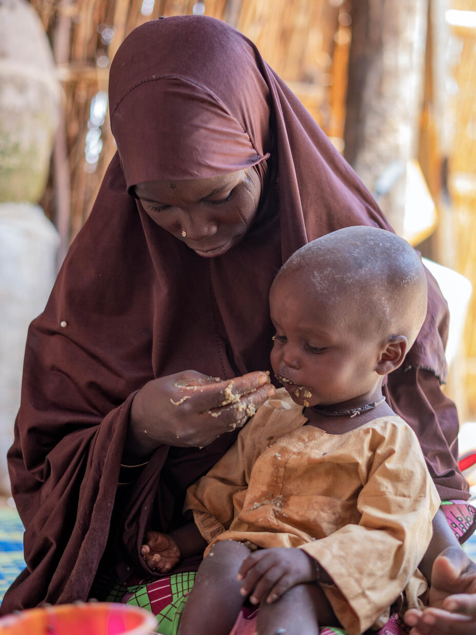 Eine Frau in Niger füttert ihr unterernährtes Kind