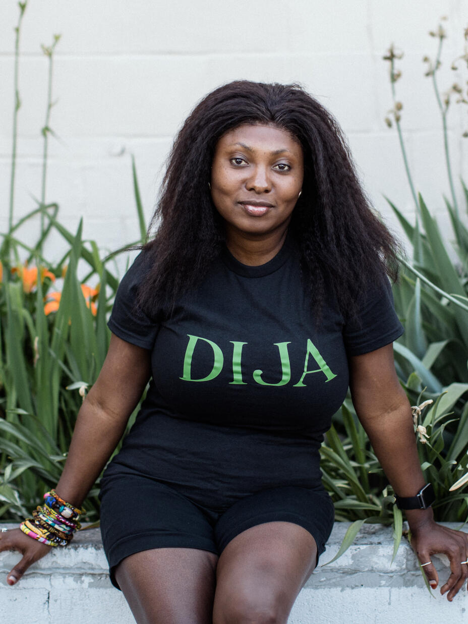 Kadijatu Grace Ahene sits in front of a garden