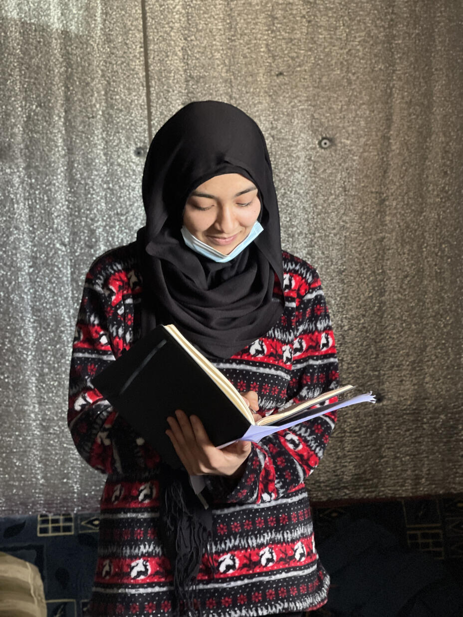 Portrait of Lina looking down, holding a book