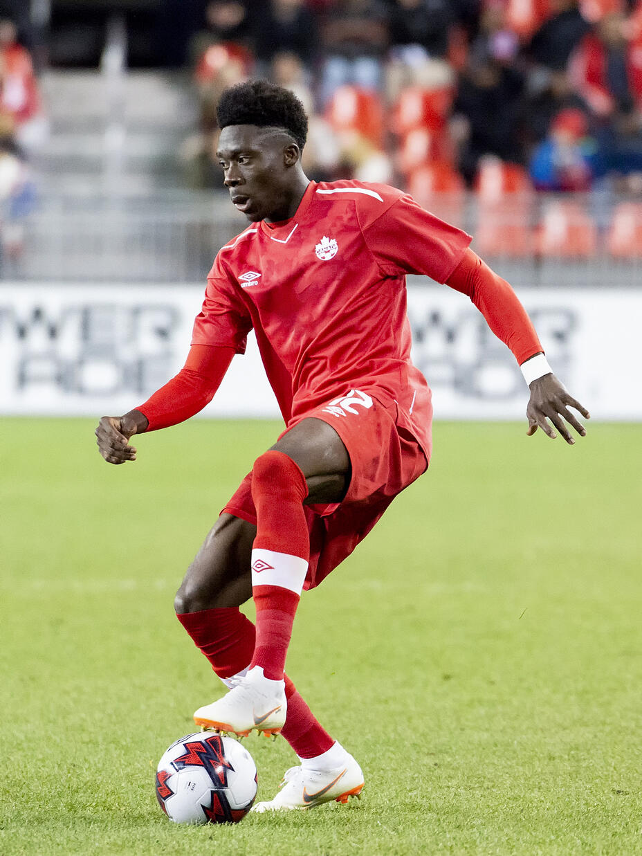 Alphonso Davies controls the ball in match.