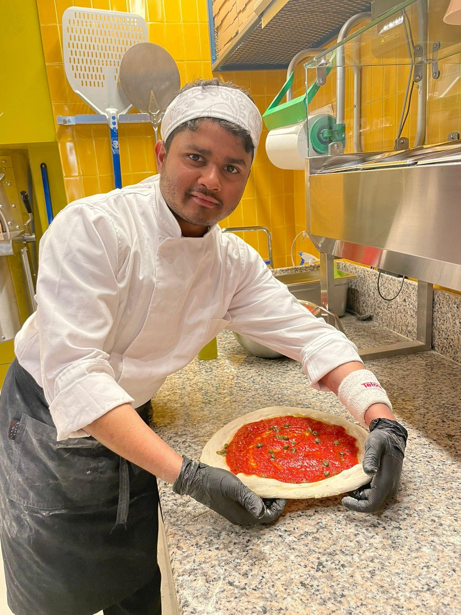 Parwan holding a pizza