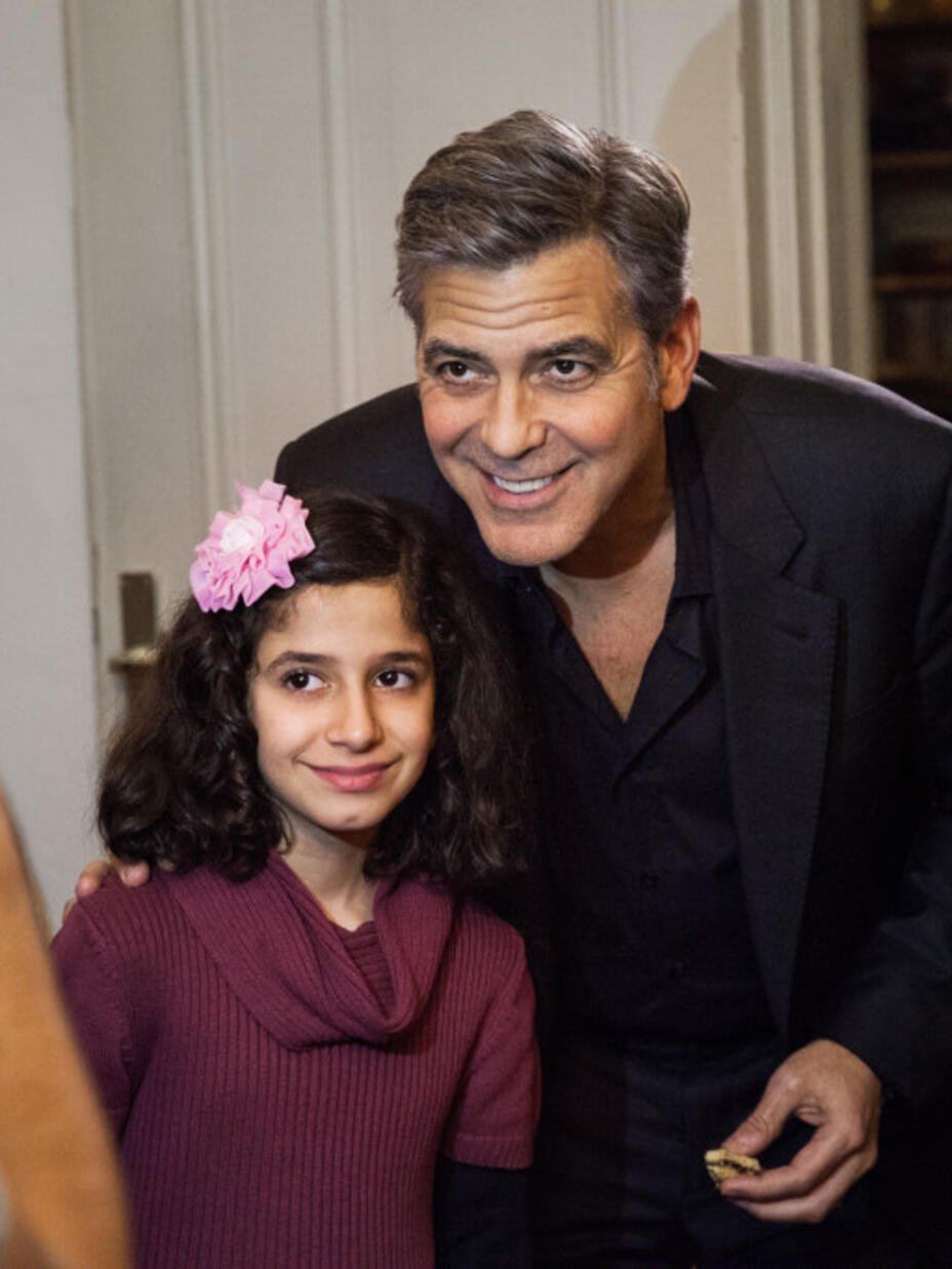 George Clooney taking a photo with a Syrian Refugee in Berlin.