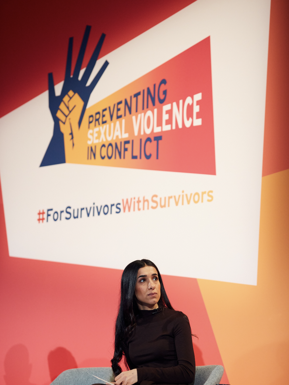 nadia murad at an event sat in a grey chair