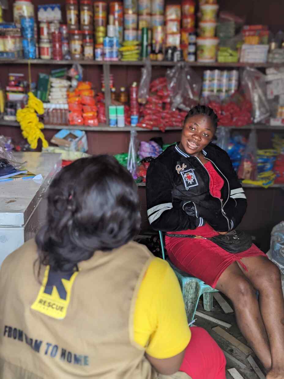 An IRC staff member meets Mercy at her provisions store in Buea, Cameroon. Together, they reflect on the progress of the business.